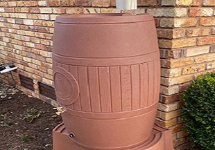 Collecting rainwater in rainwater collection barrels is one of the gutter services provided by Rain Guard gutter company.